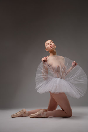 Captivating ballet dancer in a graceful pose on a minimalist stageの写真素材