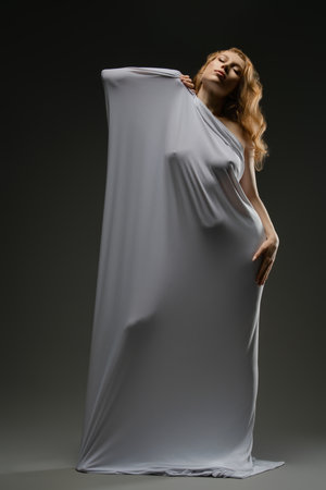 Sensual portrait of a woman in delicate lingerie with elegant draping fabricの写真素材