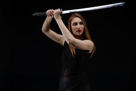 Woman in lingerie elegantly poses with a sword in a dramatic settingの写真素材