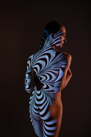 Artistic display of light and shadows on a woman's bodyの写真素材