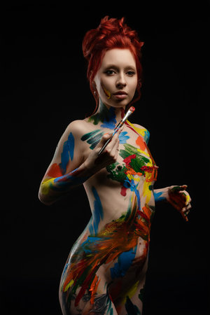 Woman showcasing body art with vibrant colors in a creative expressionの写真素材