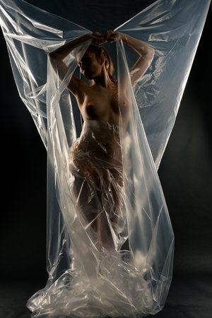 Naked woman with gold art posing against a large film backdropの写真素材