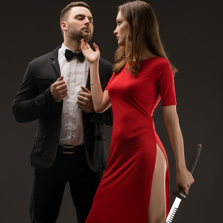 Mysterious encounter between a woman in red and a suited man at nightの写真素材