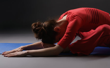 Fitness. Studio photo of girl warming up on matの写真素材