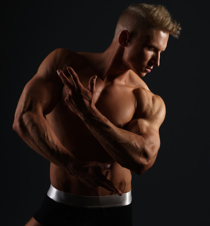 Sexy bodybuilder in briefs posing in his profileの写真素材
