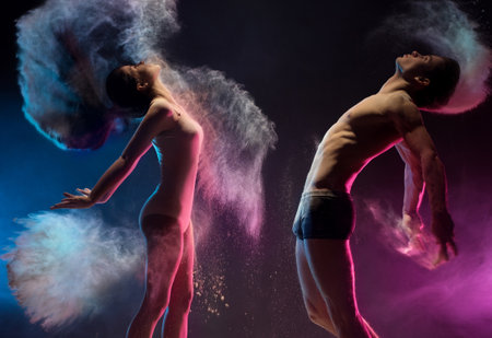 Young couple poses in color dust cloud studio shotの写真素材