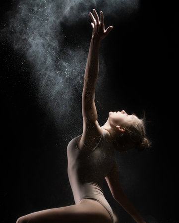 Female gymnast dances in cloud of white powderの写真素材