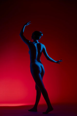 Sensual silhouette of a woman posing gracefully against a vivid backgroundの写真素材