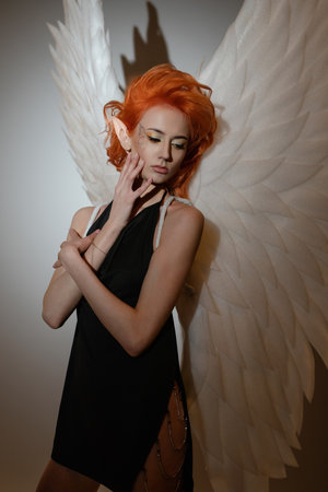 Beauty woman poses with angel wings in a creative studio settingの写真素材