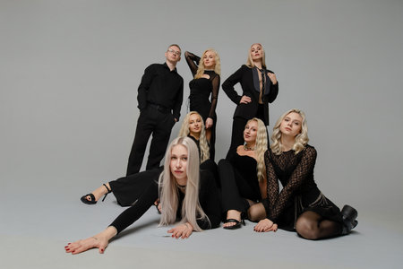 Group of stylish individuals posing together in black attire against a neutral backgroundの写真素材