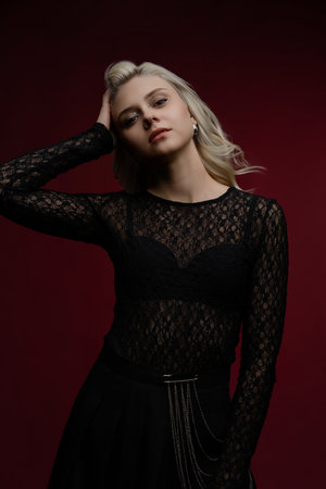 Elegant woman posing in black lace top with a dramatic backgroundの写真素材