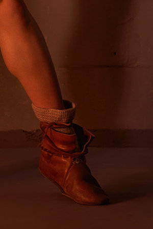 Detail of a leg in a rustic brown leather Viking-style bootの写真素材