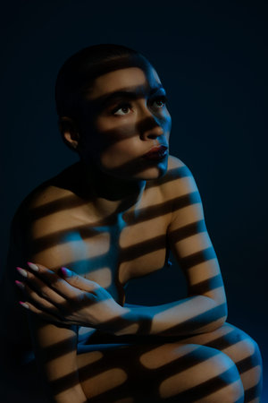 Elegant beauty in striking light and shadow amidst a dramatic settingの写真素材