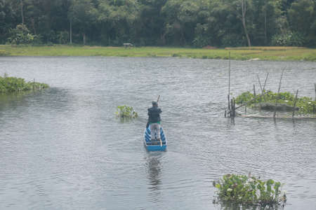 man rowing a small boatの写真素材