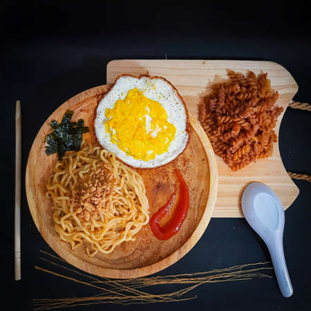 Fried noodle flavored macaroni in a wooden plate. photo from top viewの写真素材