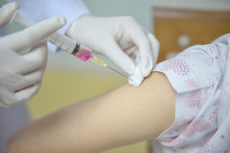 Soft focus nurses are vaccinations to patients using the syringe.Doctor vaccinating women in hospital.Are treated by the use of sterile injectable upper arm. injectionの写真素材
