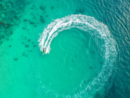 People are playing a jet ski in the sea.Aerial view. Top view.amazing nature background.The color of the water and beautifully bright. Fresh freedom. Adventure day.clear turquoise at tropical beachの写真素材