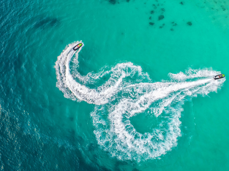 People are playing a jet ski in the sea.Aerial view. Top view.amazing nature background.The color of the water and beautifully bright. Fresh freedom. Adventure day.clear turquoise at tropical beach.の写真素材