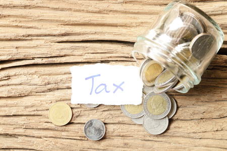 word tax with money on wooden tableの写真素材