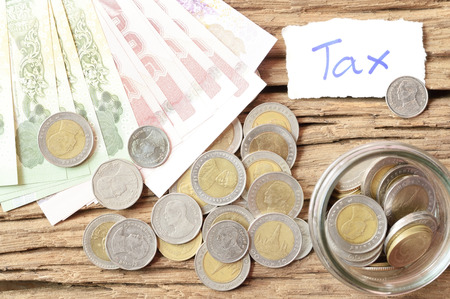 word tax with money on wooden tableの写真素材
