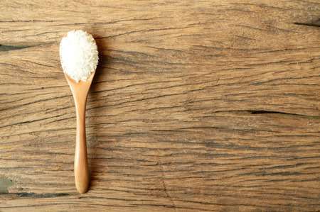 white rice in spoon on wooden backgroundの写真素材