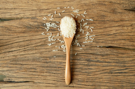 white rice in spoon on wooden backgroundの写真素材