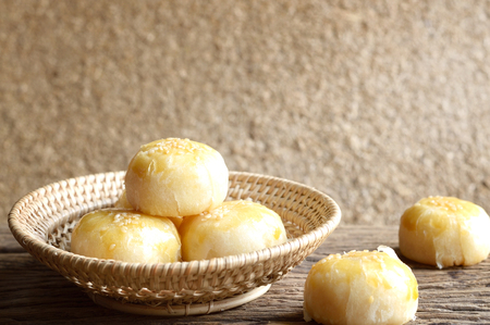 chinese pastry or moon cake in wicker basket on wooden table, chinese festival dessertの写真素材