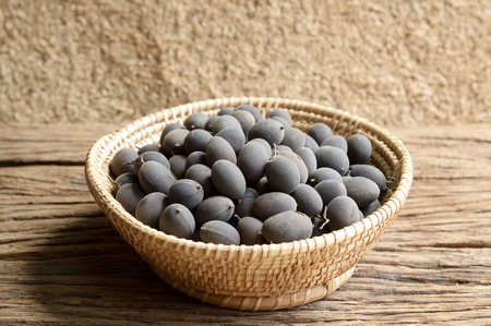 dialium cochinchinensis or velvet tamarind fruit on wood tableの写真素材