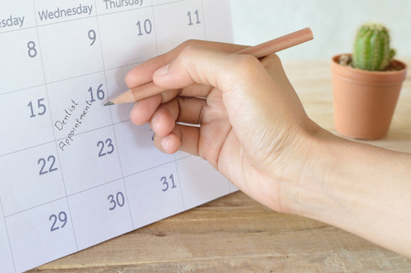 woman write dentist appointment in calendar planner for reminderの写真素材