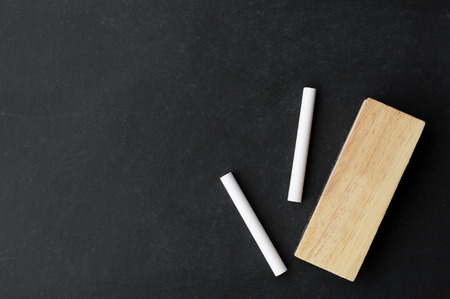 chalk and eraser on chalkboard with copy space, ready for your messageの写真素材