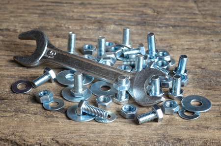 wrench and nuts and bolts on wooden tableの写真素材