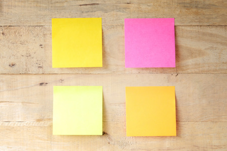 empty colorful sticky notes on wooden bulletin board, ready for messageの写真素材