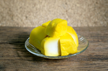 yellow tofu in glass dish on wooden table, prepared for chinese food cookingの写真素材