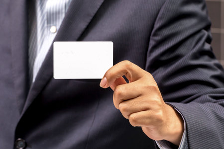 Business man handing a blank business card at his office