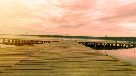 A peaceful in the wooden pier by the lake at sunsetの写真素材