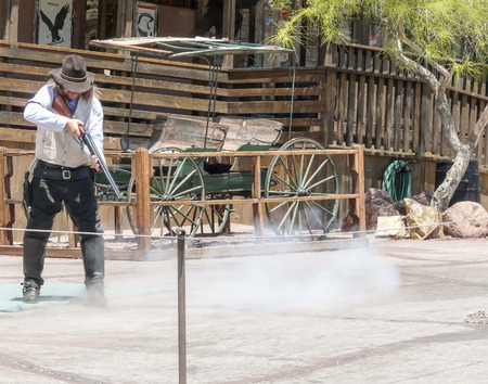 Calico CA USA  May 18 2008: Cowboy maybe sheriff shooting with rifle at old carriage in Calico Ghost Town abandoned and obsolete silver mining town in the Mojave desert.のeditorial素材