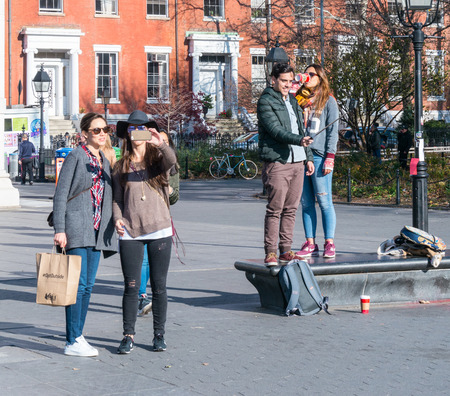 Manhattan, New York - December 06, 2015: People making selfies during lazy Sunday afternoon in Washington Square Park.のeditorial素材