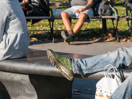 Manhattan, New York - December 06, 2015: People sitting and laying on the benches  during lazy Sunday afternoon in Washington Square Park.のeditorial素材