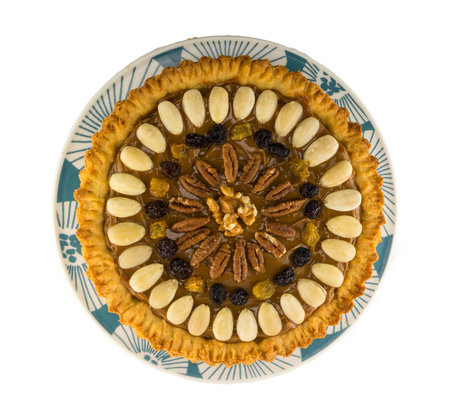 Round traditional Polish Easter cake "Mazurek" with almonds, raisins and walnuts on the white background.の写真素材