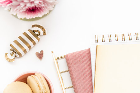Feminine desktop with gold and pink stationery including fresh flowersの写真素材