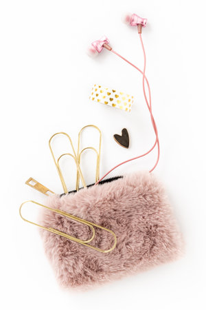 Feminine gold and pink items including stationery, earbuds, purse and heartの写真素材