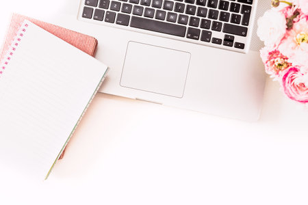 Feminine desktop with gold and pink stationery including a keyboard and mouseの写真素材