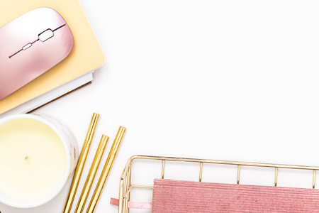 Feminine desktop with gold and pink stationery including a keyboard and mouseの写真素材
