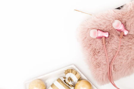 Feminine desktop with gold and pink earbuds, purse and sweet treatsの写真素材