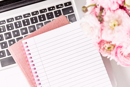 Feminine desktop with gold and pink stationery including a keyboard and mouseの写真素材