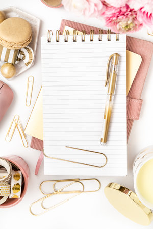 Feminine desktop with gold and pink stationery including a keyboard and mouseの写真素材