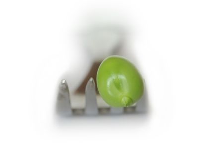 green peas on fork on white backgroundの写真素材