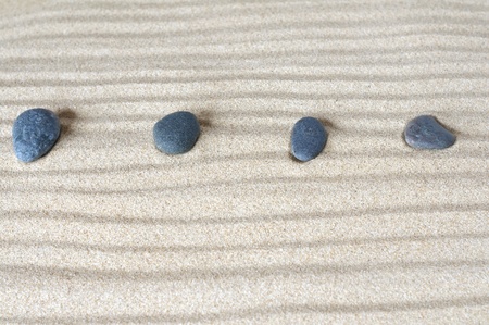 four stones on background of sand