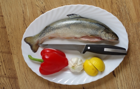 trout on white plate on woodの写真素材