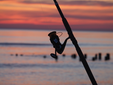 fishing-rod with spinning-wheel on sea backgroundの写真素材